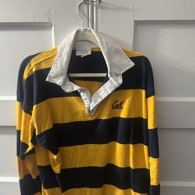 Navy and gold striped Cal rugby shirt on a hanger